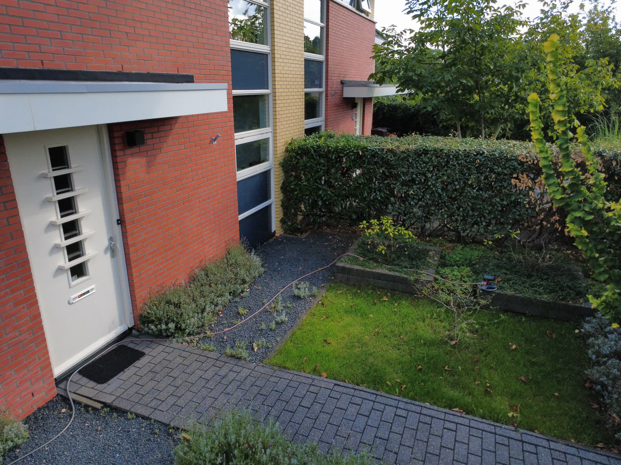 Voordeur met tegelpad, grind en voortuin