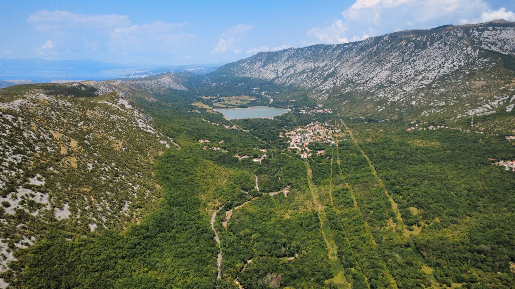 Dorpje in een groen dal met bergen en een meer