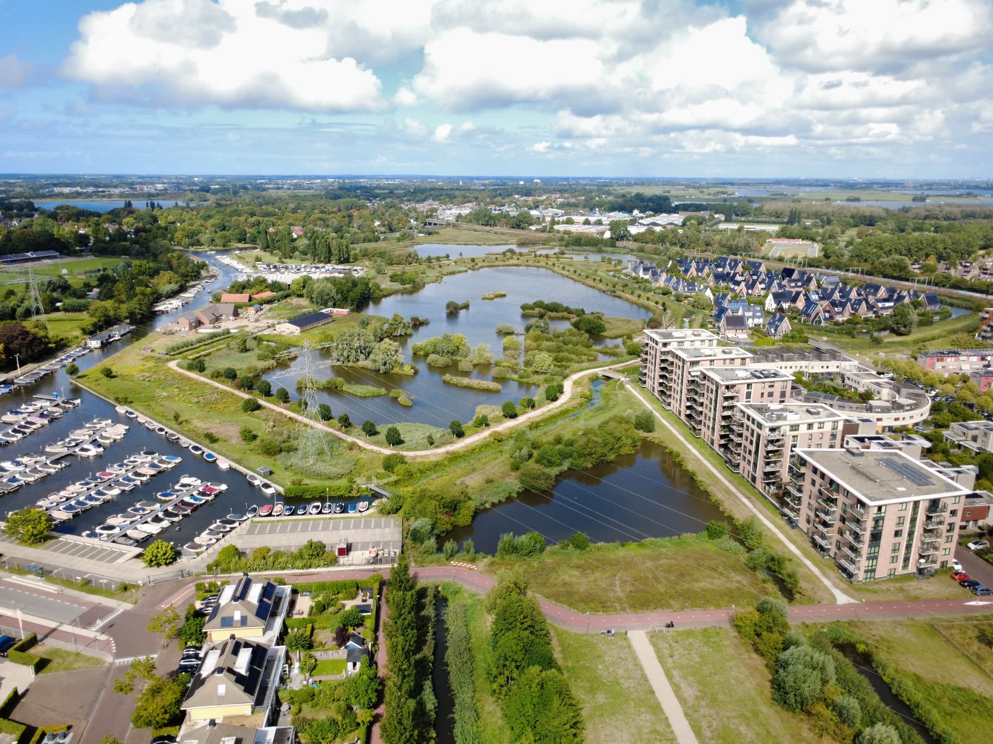 Luchtfoto van een woonwijk aan het water met jachthaven en groen