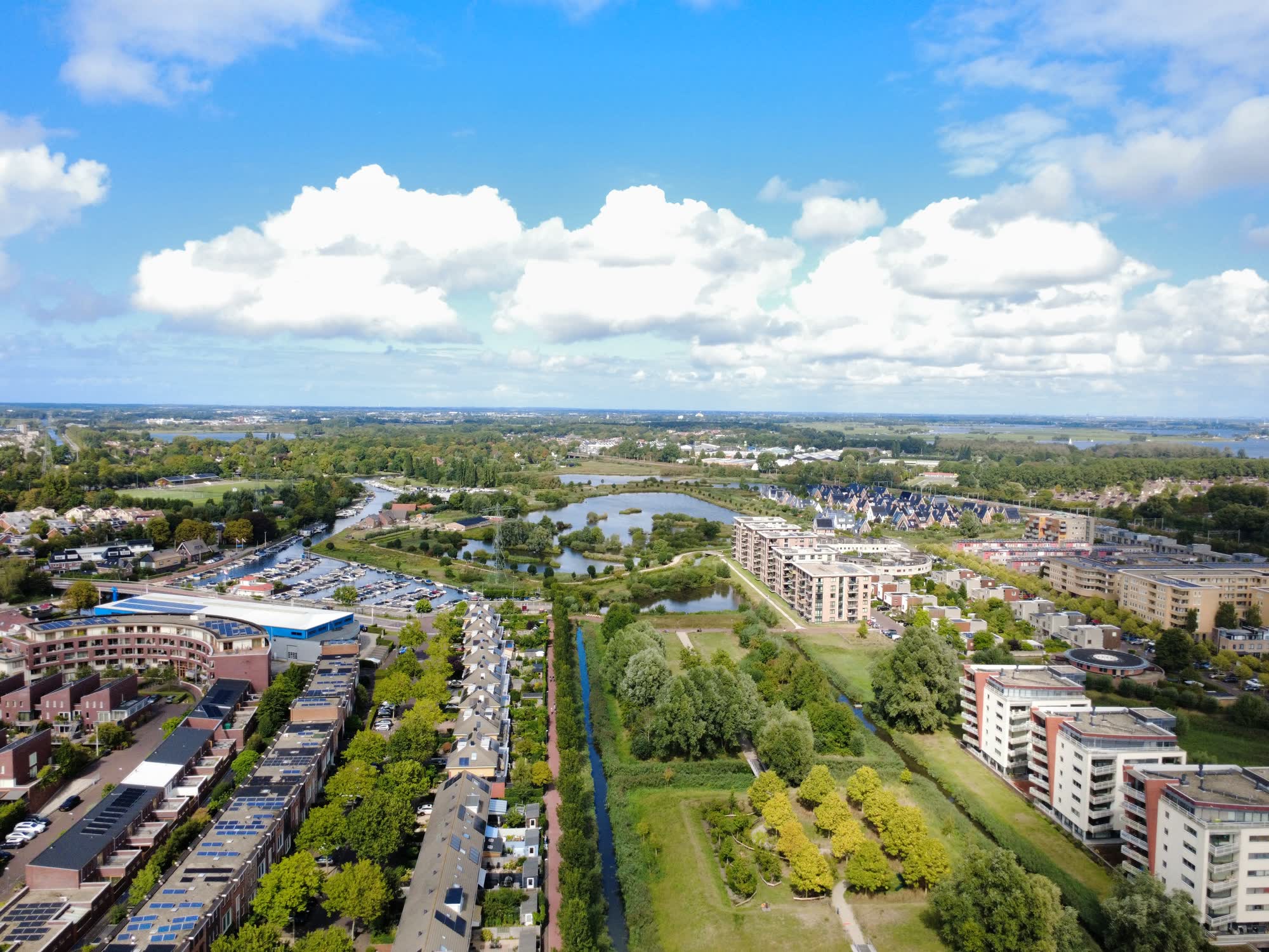 Luchtfoto van een woonwijk met water, groen en een jachthaven