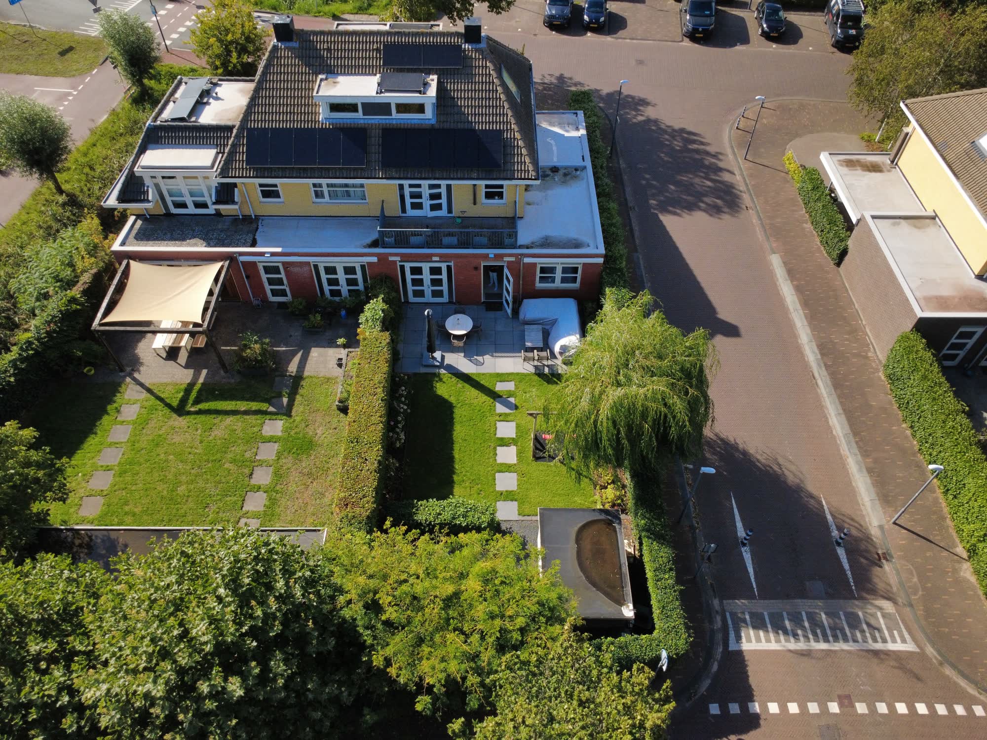 Achterkant van het huis met terras, balkon en een diepe tuin