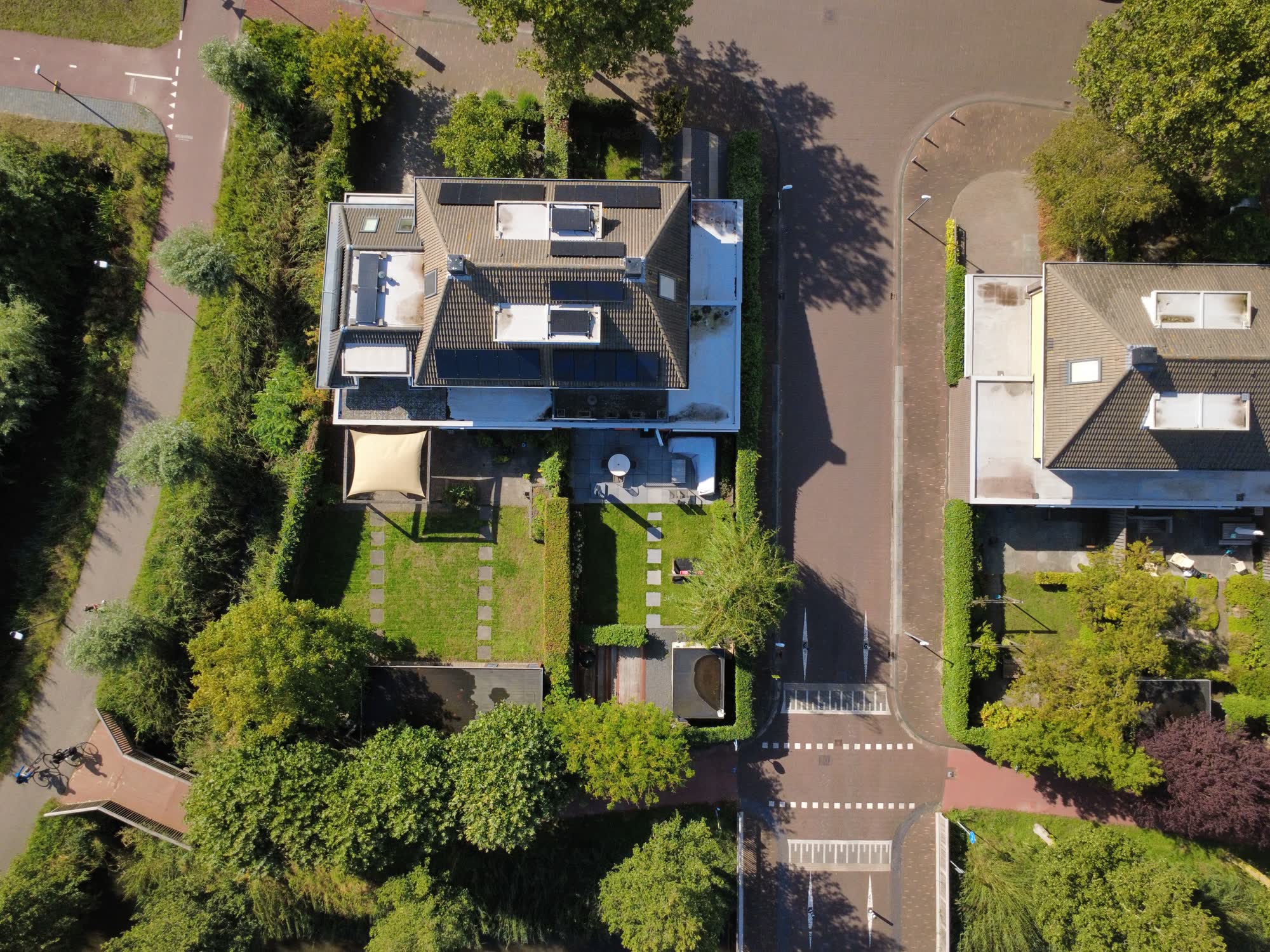Huis met voortuin, achtertuin en oprit, recht van boven gefotografeerd